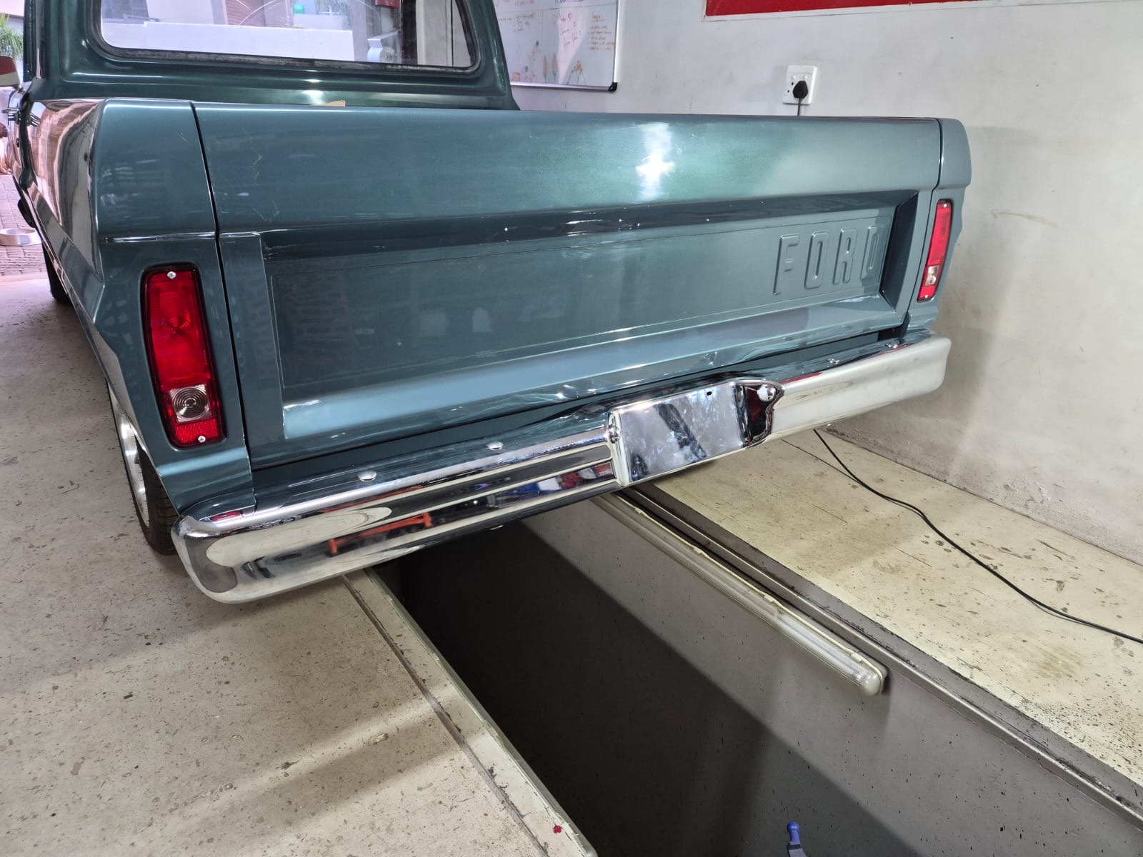 Three-quarter rear workshop view of the Ford F100